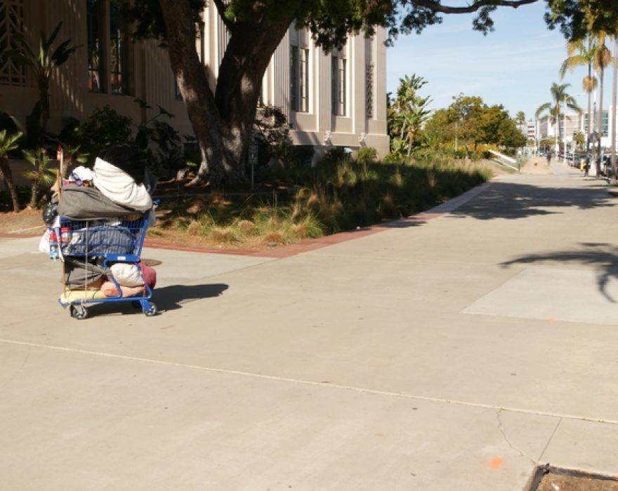 Stuff of homeless street people on walkway, truck on roadside. San Diego, California. (Photo:© Dogorasun | Dreamstime.com)